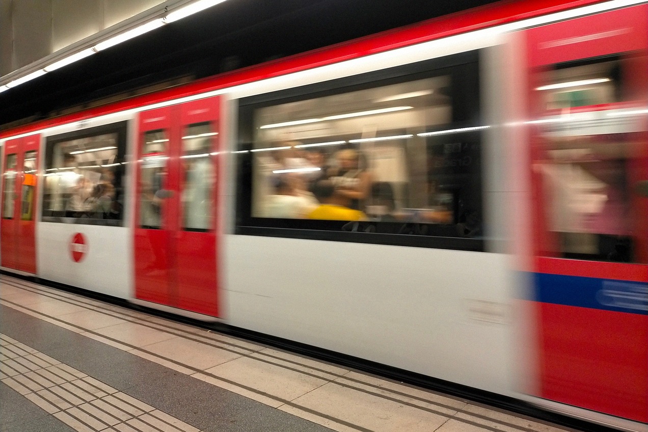 Tren de metro rojo y blanco entrando en una estación subterránea de Barcelona